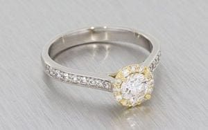 A Palladium Round Brilliant diamond halo ring housed in a 14k rose gold setting
