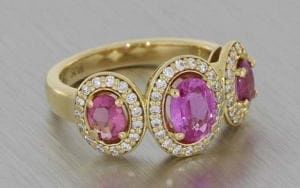 Striking Yellow Gold Trilogy Ring With Three Oval Pink Sapphires Surrounded By Diamond Halos