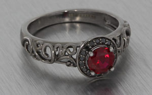 黑色镀铑戒指集黑钻石和一颗圆形红红宝石